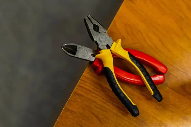 Photo of tool home master. Pliers rubber handles on a wooden lathe two pairs
