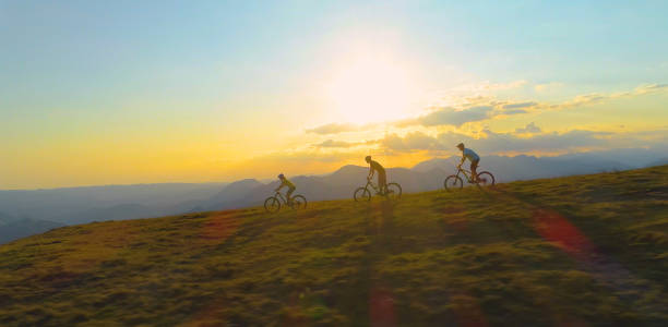 드론 : 산악 자전거 의 그룹은 화창한 봄 날에 잔디 언덕아래로 속도. - bikers point of view 뉴스 사진 이미지