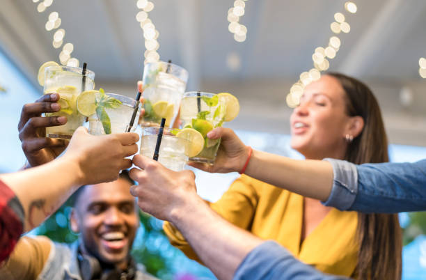 meilleurs amis buvant ensemble au restaurant de bar de mode - concept d'amitié avec des jeunes ayant bu des boissons de pain grillé d'amusement sur l'happy hour au pub - filtre de néon vif avec l'accent sur des cocktails de mojito - cocktail alcool photos et images de collection