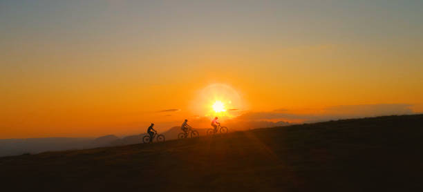 istock COPY SPACE: Three downhill bikers pedalling their bicycles up a hill at sunrise. 1185007429