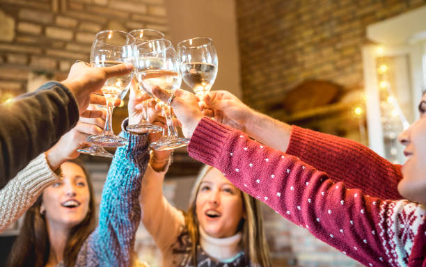 amigos felices celebrando el vino de champán de navidad en la cena casera - concepto de vacaciones de invierno con los jóvenes disfrutando del tiempo juntos divirtiéndose en la cabaña de troncos - filtro caliente con enfoque en las copas - drinking little girls women wine fotografías e imágenes de stock