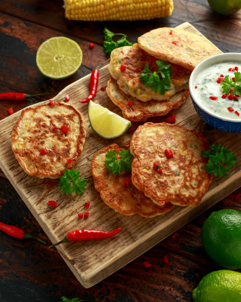 istock Corn fritters, pancake with dip white sauce, lime and chilli on wooden board 1185013638