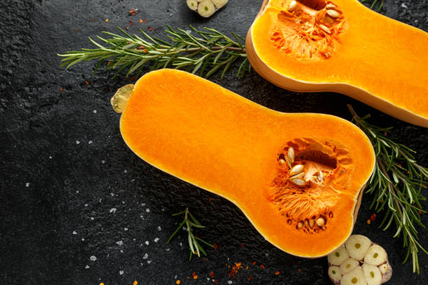 istock Fresh Butternut squash with rosemary, garlic, chilli flake and salt on black rustic background 1185013880