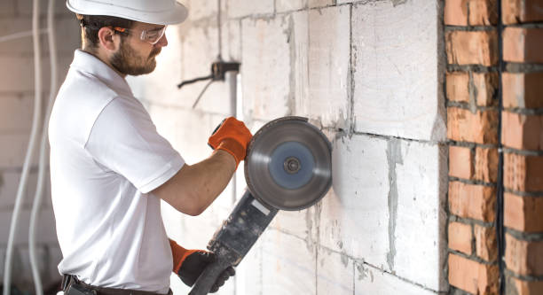 istock The industrial Builder works with a professional angle grinder to cut bricks and build interior walls. Electrician. 1185014827