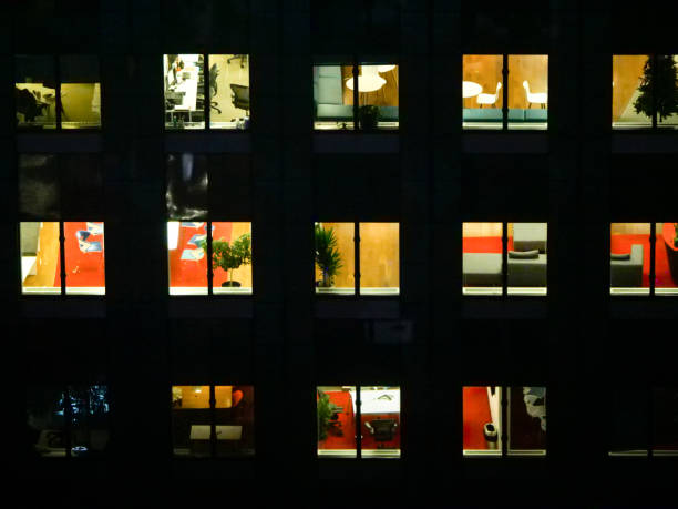 istock CLOSE UP: People extending their workdays late into the night in glassy building 1185015898
