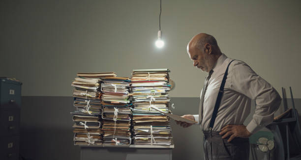 istock Businessman checking files and piles of paperwork 1185015904