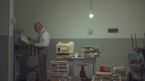 istock Businessman searching for files in a messy office 1185016023