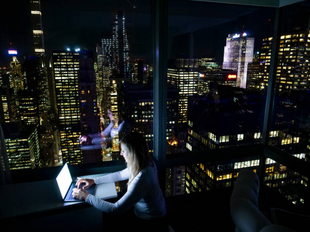 istock CLOSE UP: Woman working at night on her computer, trying to finish a project. 1185016247