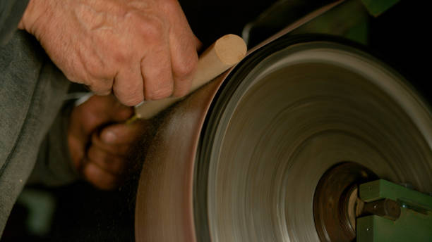istock CLOSE UP: Man sandpapering a piece of wood into a knife handle in his workshop. 1185018409