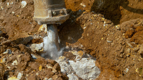 istock CLOSE UP: Jackhammer creates a cloud of dust as it strikes against solid rock. 1185019424