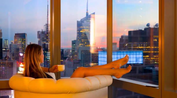 istock CLOSE UP: Relaxed woman drinking tea and watching the cityscape on sunny evening 1185019938