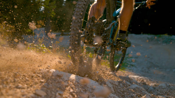 istock CLOSE UP, DOF: Mountain biker kicking up dust and rocks while braking hard 1185022960