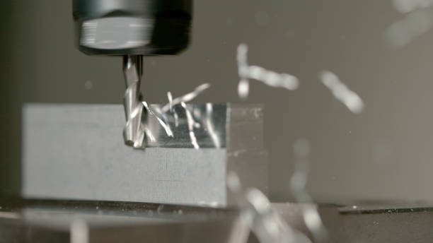istock MACRO, DOF: Sharp end mill shaves the side of a small aluminium workpiece. 1185025138