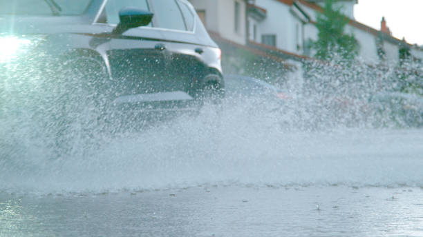 istock LOW ANGLE: Large car drives through the suburbs during a heavy spring rainstorm. 1185026314