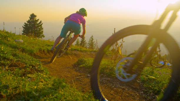 istock LENS FLARE Four mountain bikers ride into a sharp turn on a sunny spring evening 1185026749
