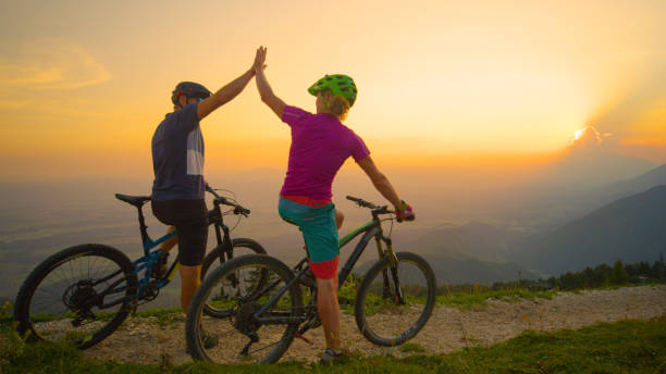 istock COPY SPACE: Cheerful friends high five at sunset after successful bicycle ride. 1185026811