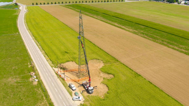 istock DRONE: Maintenance crew working on an electricity pylon next to asphalt road. 1185027752