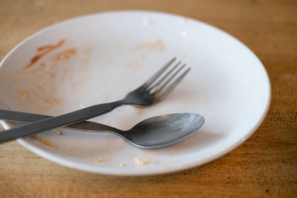 istock Dirty plate with spoon and fork after a meal. Close up 1185030226