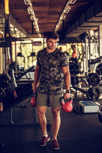 istock Athletic young man finishing a work out with kettle bells 1185031330