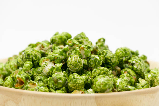 Japanese matcha green tea popcorn in the wooden bowl bulk isolated on white background