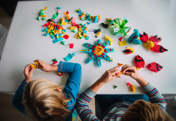 istock kids making origami crafts with paper, learning activities 1185037308