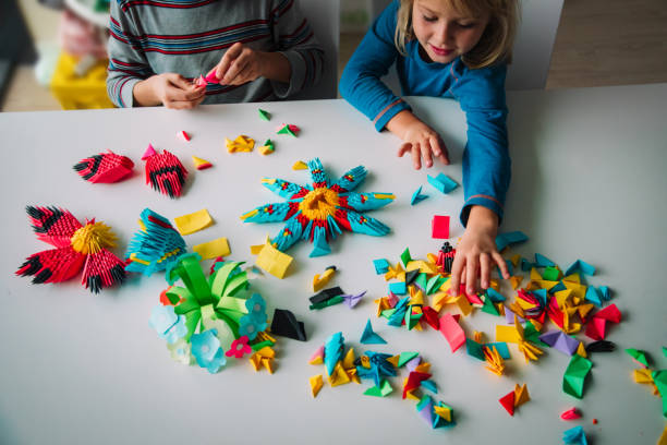 istock kids making origami crafts with paper, learning activities 1185037595