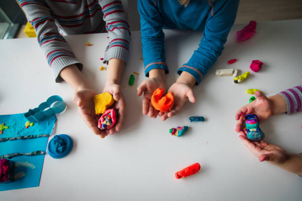 istock kids play with clay molding shapes, learning through play 1185040135