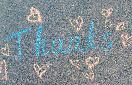 The inscription thank you in chalk on the pavement. Selective focus. nature.