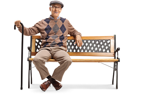 Full length shot of a happy senior gentleman sitting on a bench isolated on white background