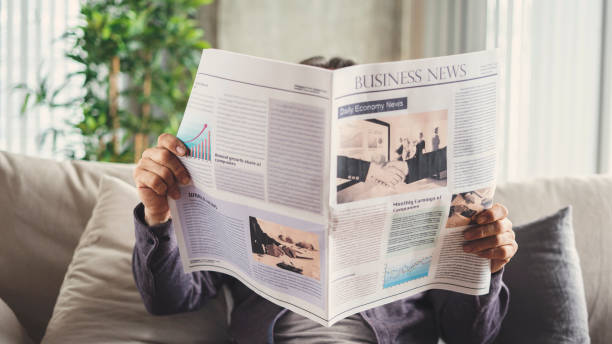 istock Senior man reading newspaper at home 1185054359