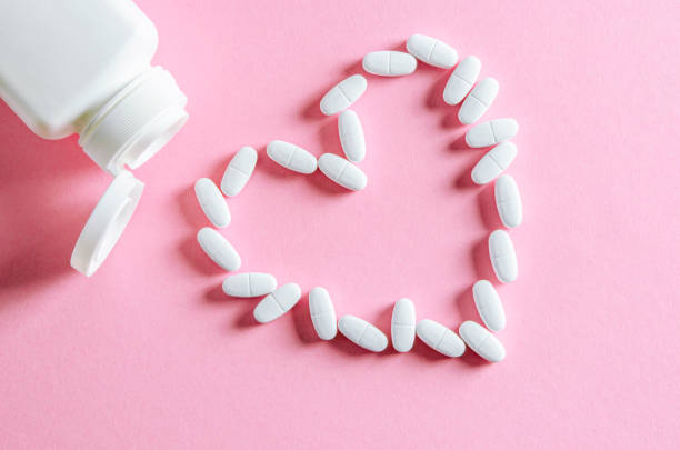 istock A white plastic container with white tablets lies on a multi-colored background next to white tablets 1185065017