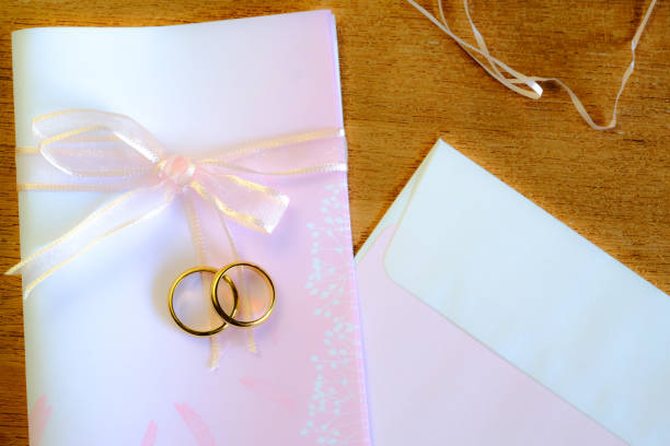 istock Duo golden wedding ring over invice card on wood table.Wedding concept. 1185065196
