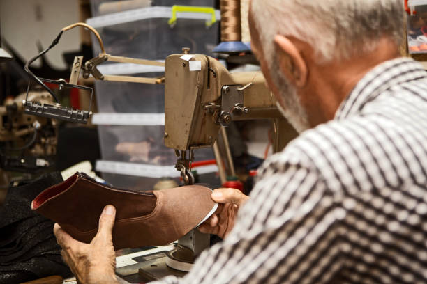 istock Shoe maker with unfinished shoes sewing machine 1185067334