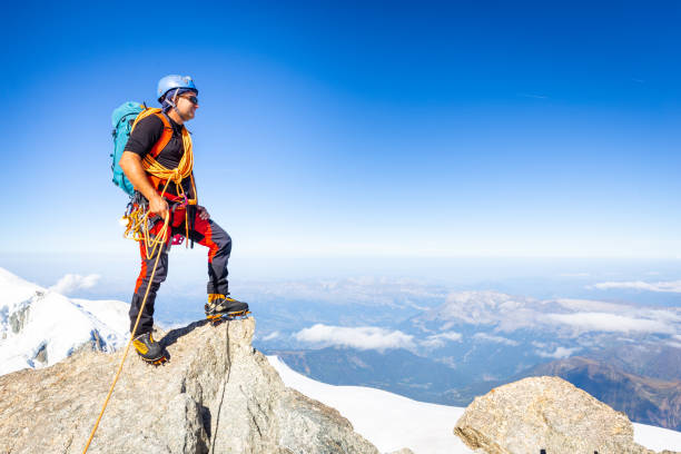 istock Alpinist mountaineer standing rock cliff mountain summit. 1185067805
