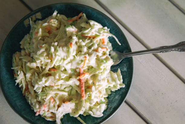 istock Coleslaw in a small bowl on a wood table. Overhead view with copy space. 1185068787