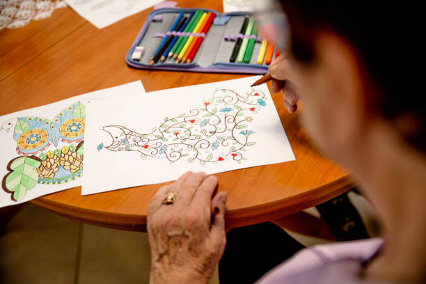 istock Senior Woman Coloring an Illustration on Table 1185069809