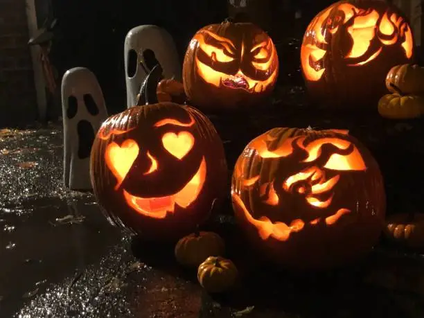 Photo of Cute Halloween Jack o’lantern pumpkins on rainy Halloween night