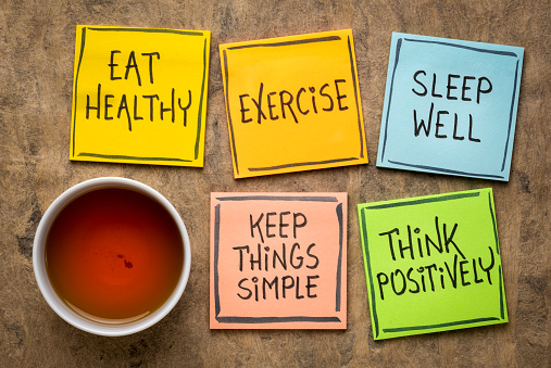 healthy lifestyle and wellbeing concept - a set of inspirational reminder notes with a cup of tea: eat healthy, exercise, seep well, keep things simple, think positively