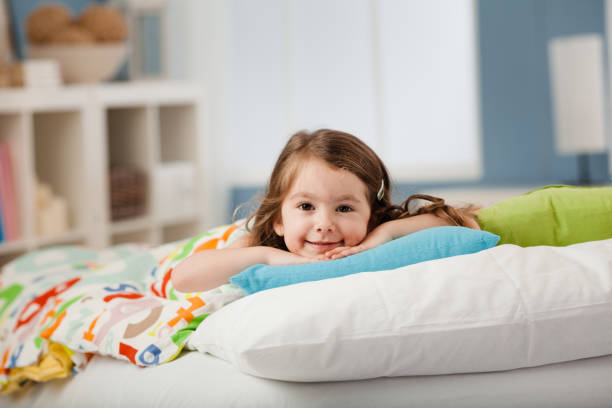 Little girl smiling lying in bed