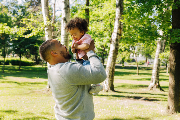 istock Happy father standing outdoors with his smiling kid. Young dad playing with a son. 1185094584