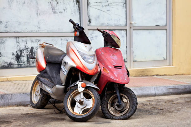 zwei alte abgenutzte mopeds stehen allein am straßenrand. - paint roller paint white painting stock-fotos und bilder