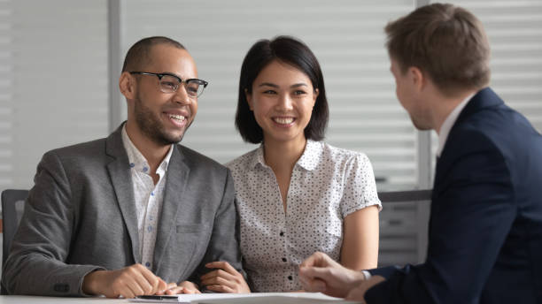 happy mixed ethnicity family couple customers listening to bank manager - lawyer family talking discussion imagens e fotografias de stock