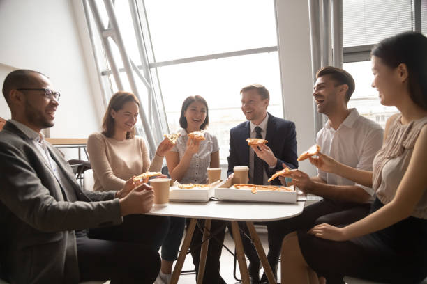 istock Happy multicultural staff workers business team having fun eating pizza 1185095757