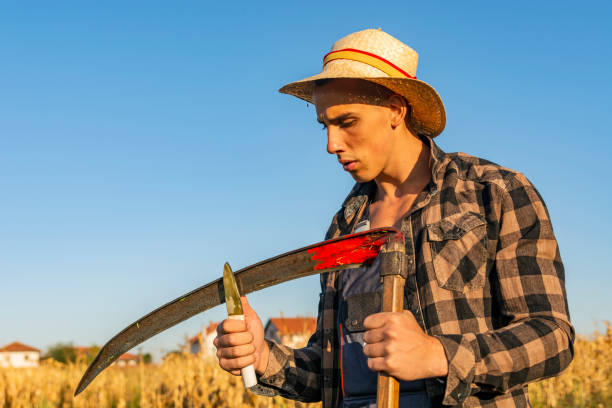 istock Farmer  sharpening his scythe for using to mow the grass traditionally 1185096896