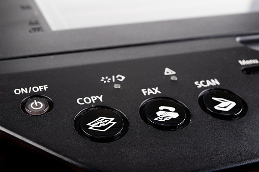 Control buttons on the printer. Control panel in photocopier. Dark background.