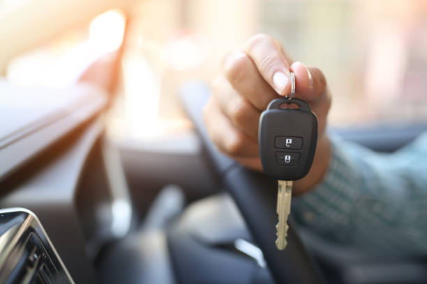 a man's hand holding a car key - chave de carro imagens e fotografias de stock