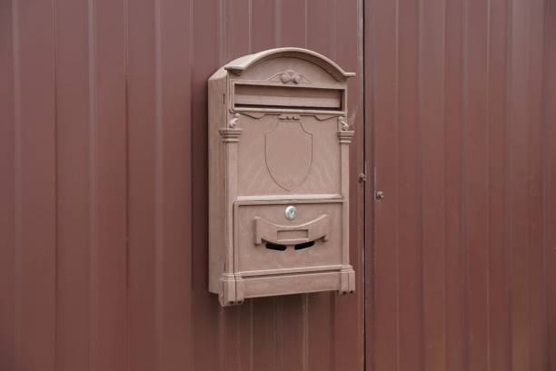 istock brown mailbox hanging on a metal fence wall 1185099166