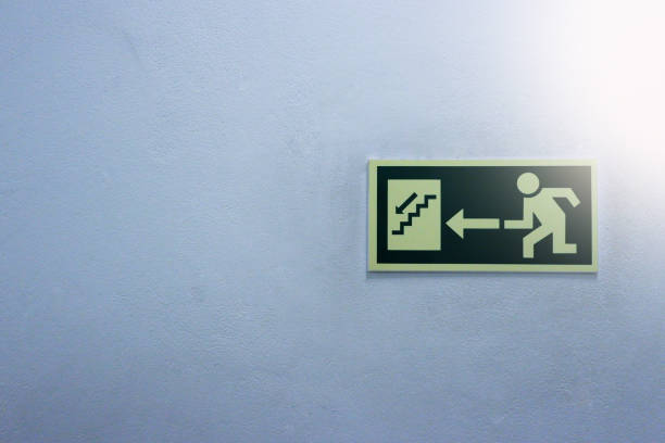 True green safety symbol for going to the fire exit in a white background. Attached to the ground