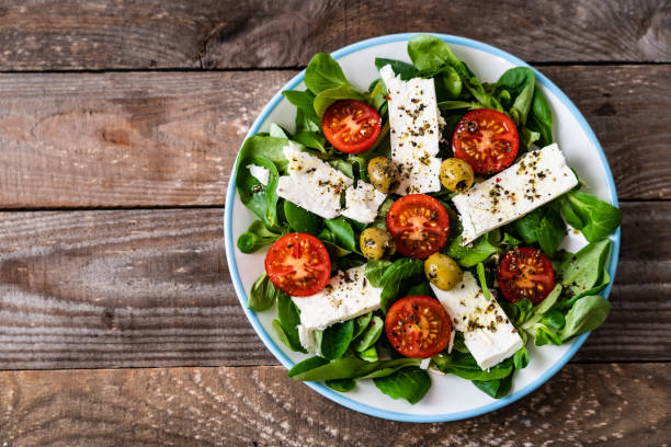 istock Greek salad on wooden background 1185111098