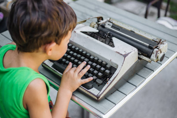 bambino con vecchio scrittore di tipo - machine typewriter human hand typing foto e immagini stock